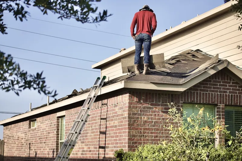 Professional roofer working on a residential roof in Country Club Manor
